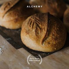 there are some breads that are on the cutting board with words alchemy