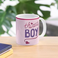 a pink coffee mug sitting on top of a wooden table