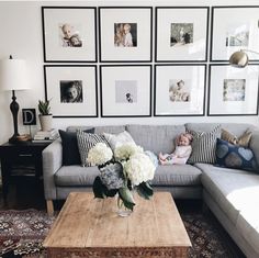 a living room with pictures on the wall and a couch in front of a coffee table