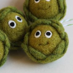 four green felt balls with eyes on them