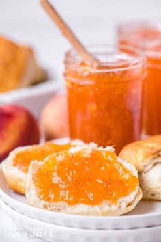 two pieces of bread on a plate with jam and peaches in the back ground