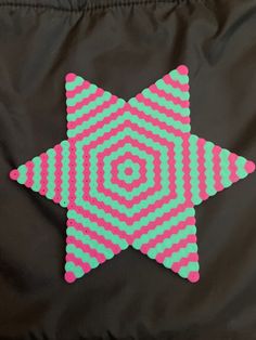 a pink and green star on a black background