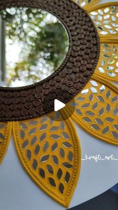 a mirror that is sitting on top of a white table with yellow and brown designs