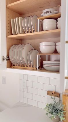 the dishes are organized on the shelves in the kitchen