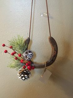 an animal's head hanging from a wall with pine cones and berries on it