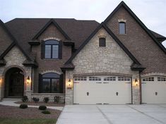 a large brick house with two garage doors