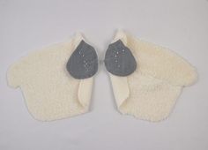 two pairs of mittens are shown on a white surface, one has a black and gray mitten