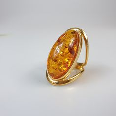 Amber ring. Brown Orange Baltic Amber gemstone ring. Certificated gold plalted Sterling silver 925 with stamps - hallmarks. Big nice stunning ring. Adjustable size. Very big and stunning amber gemstone ring. weight 11.29 gr GOLD plated ring. Stone size- 4.7 x 2 cm This item was made of natural Baltic Amber. All the amber used in my jewelry is collected in my home country Lithuania. I sell only genuine, real, not pressed, authentic, natural Baltic Amber. Item may have natural imperfections. Luxury Amber Rings For Formal Occasions, Gold Crystal Ring With Polished Finish For Formal Occasions, Elegant Gold Crystal Ring With Polished Finish, Oval Gold-plated Rings Hallmarked, Oval Gold-plated Rings For Formal Occasions, Gold Plated Oval Rings For Formal Occasions, Oval Gold Plated Rings Hallmarked, Oval Gold Plated Rings, Oval Gold Plated Rings For Formal Occasions