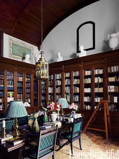 a living room filled with lots of furniture and bookshelves covered in bookcases