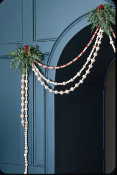 the door is decorated with beads and greenery