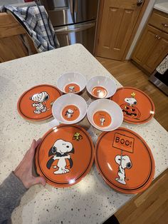 a person is holding several orange plates with cartoon dogs on them