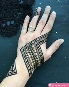 a woman's hand with henna tattoos on it