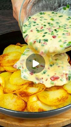 a person pouring sauce on some potato wedges in a skillet with other potatoes