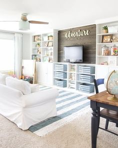 a living room filled with furniture and a flat screen tv on top of a wooden shelf