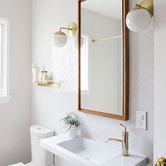 a bathroom with a sink, mirror and toilet