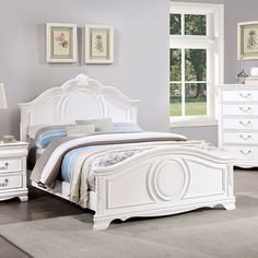 a white bed sitting in a bedroom next to a dresser and mirror on top of a wooden floor