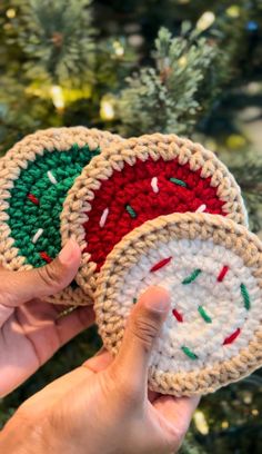 two crocheted coasters in front of a christmas tree with green and red sprinkles