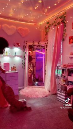 a woman in a pink room with lights on the ceiling