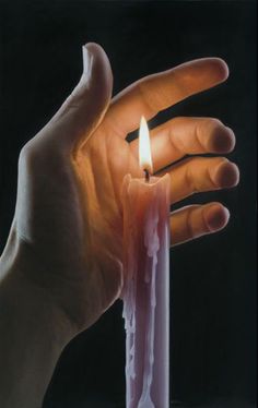 a person holding a lit candle in their hand