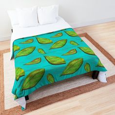 a bed with green leaves on it in a room next to a rug and pillows