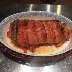 a large piece of meat sitting in a bowl on top of a metal countertop