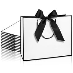 a white bag with black ribbon tied around the front and side, on a white background