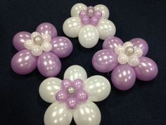 three balloons with flowers and pearls on them