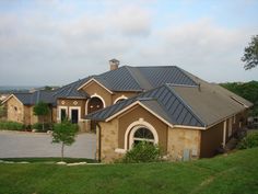 a large house with a lot of windows on the front and side of it, surrounded by green grass