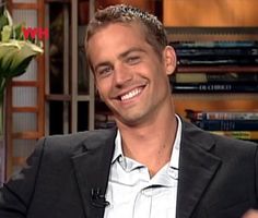 a smiling man in a black jacket and white shirt