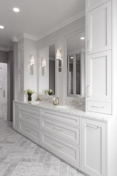 a large bathroom with white cabinets and marble floors