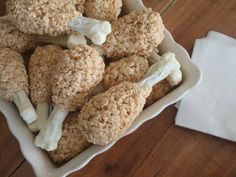 a white bowl filled with mushrooms on top of a wooden table next to a napkin