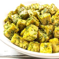 a white bowl filled with tofu and broccoli