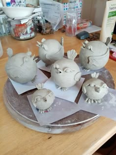 some white clay animals sitting on top of a wooden table