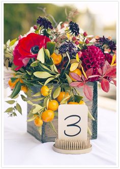 an arrangement of flowers in a vase with a table number