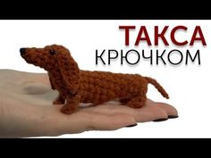 a crocheted dachshund dog sitting on top of someone's hand