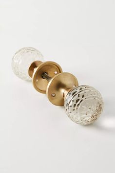 two glass door knobs on a white surface