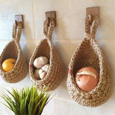 three baskets hanging on the wall with food in them