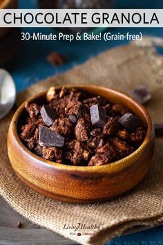 a wooden bowl filled with chocolate granola on top of a blue and brown cloth