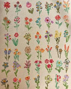 an embroidered wall hanging with flowers on it