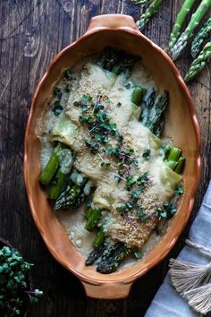 a casserole dish with asparagus and parmesan cheese