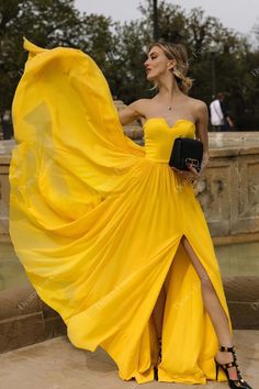 a woman in a yellow dress posing for the camera with her hand on her hip