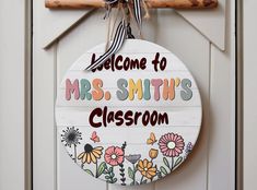 a welcome sign hangs on the front door of a classy classroom with flowers and butterflies