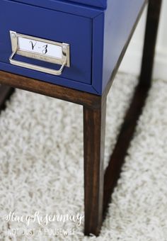 a blue desk with a clock on it and a white rug in front of it