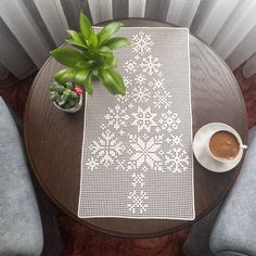 a table with two chairs and a potted plant next to it on top of a wooden table