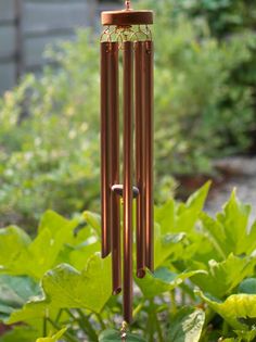 a wind chime in the middle of some plants