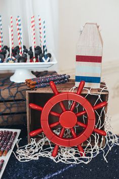 there is a boat wheel on top of a table with other items in the background