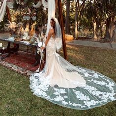 a woman in a wedding dress is standing under a gazebo with flowers on it