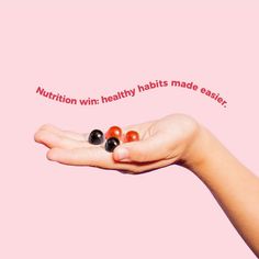 a woman's hand holding three balls with the words nutrition win healthy habit made easier