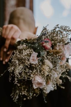 a person holding a bouquet of flowers in their hands