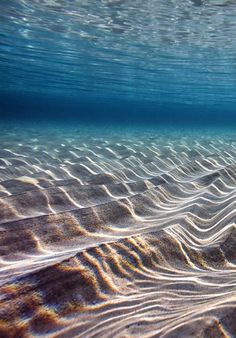 an underwater view of sand and water